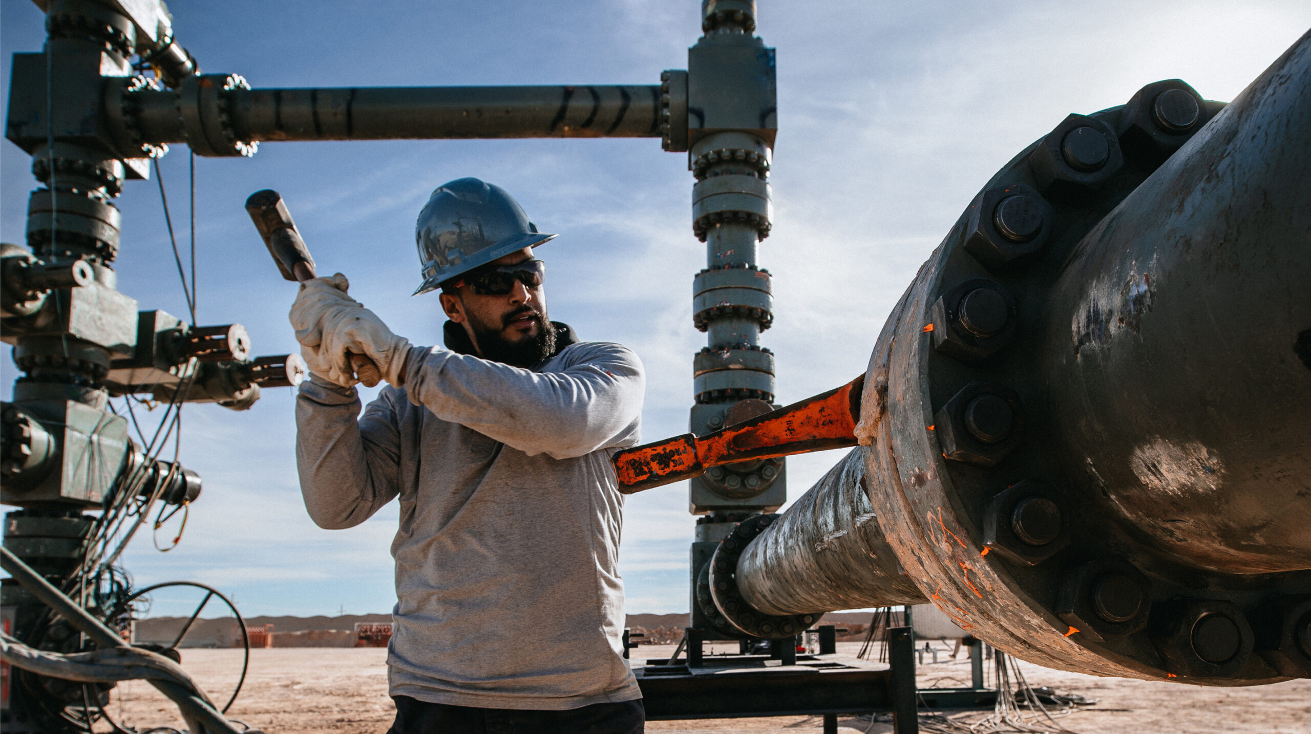 Energy operations worker performing maintenance on industrial pipeline equipment