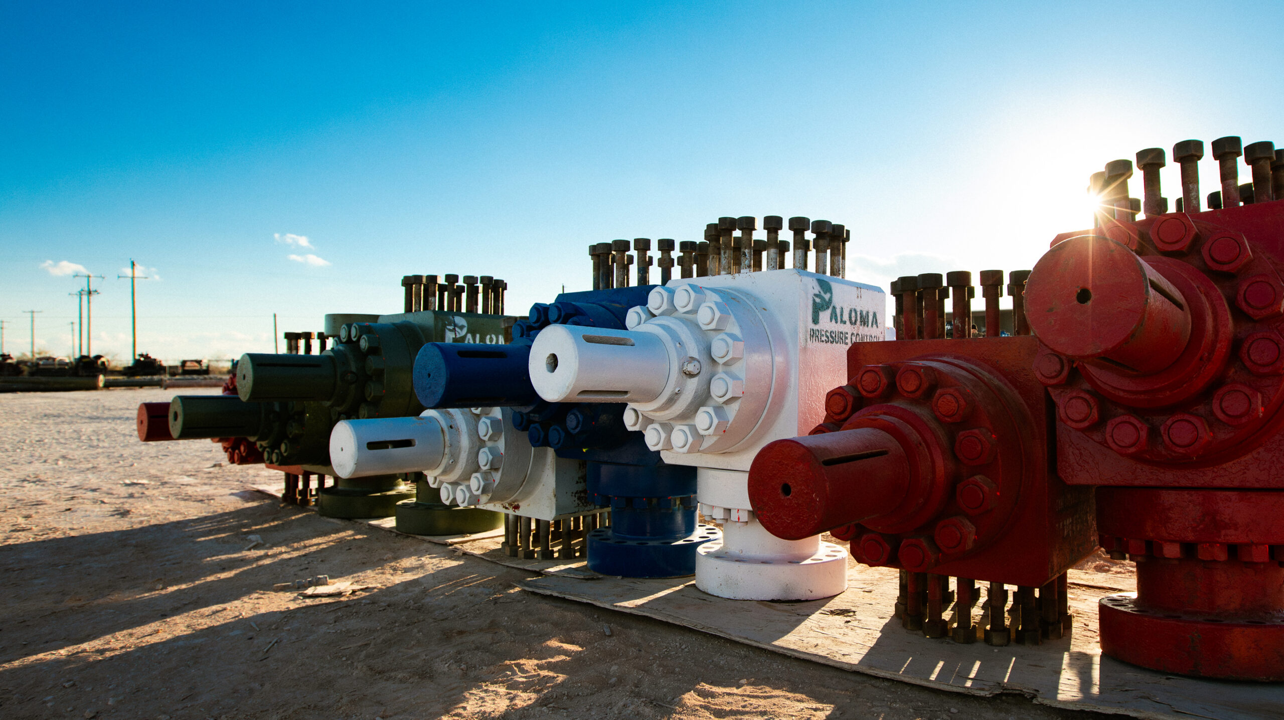 Industrial pressure-control equipment in the energy field at sunset